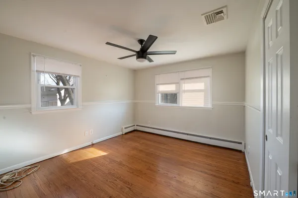 a view of a room with wooden floor and windows