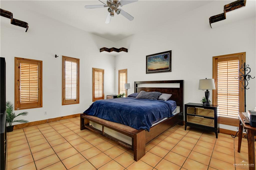 2701 Easy Street Edinburg, TX 78539 - Photo 14 of 22 a spacious bedroom with a bed and a chandelier