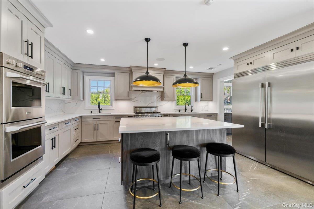 205 Hewlett Neck Road Woodmere, NY 11598 - Photo 11 of 50 a kitchen with cabinets and chairs