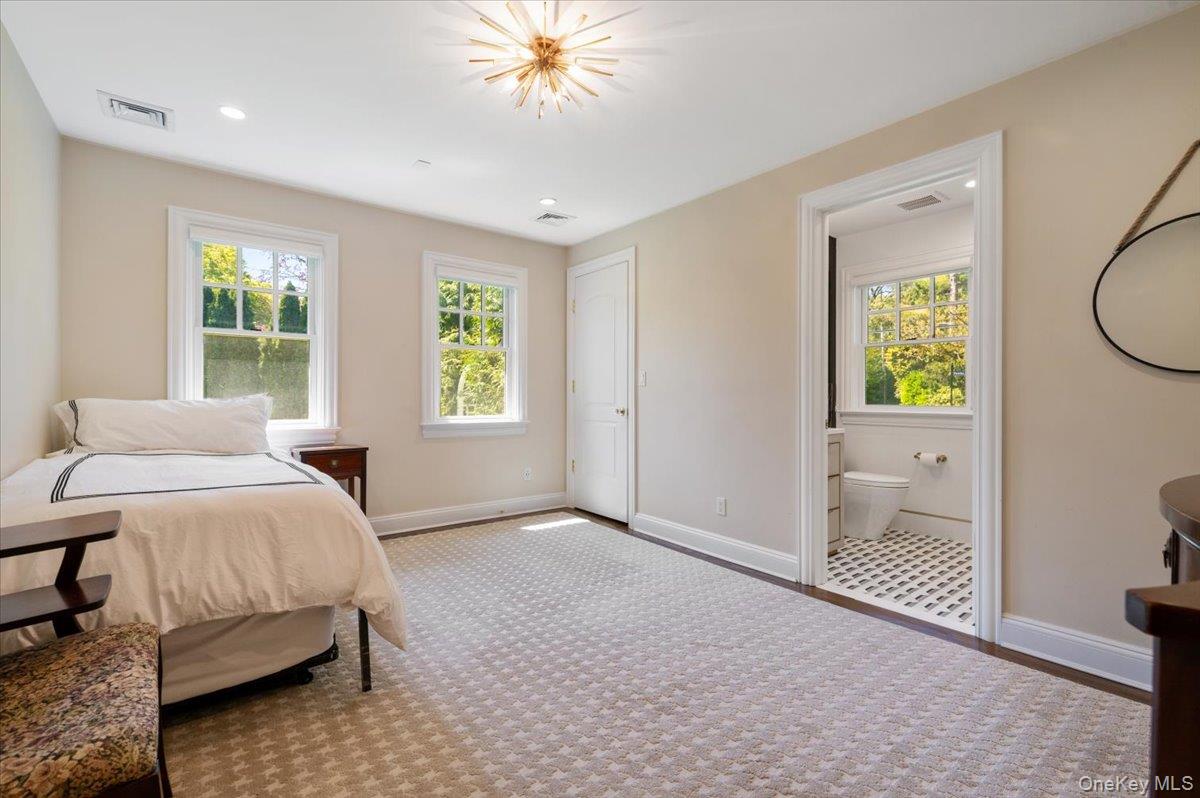 205 Hewlett Neck Road Woodmere, NY 11598 - Photo 20 of 50 a bedroom with a bed and a chandelier