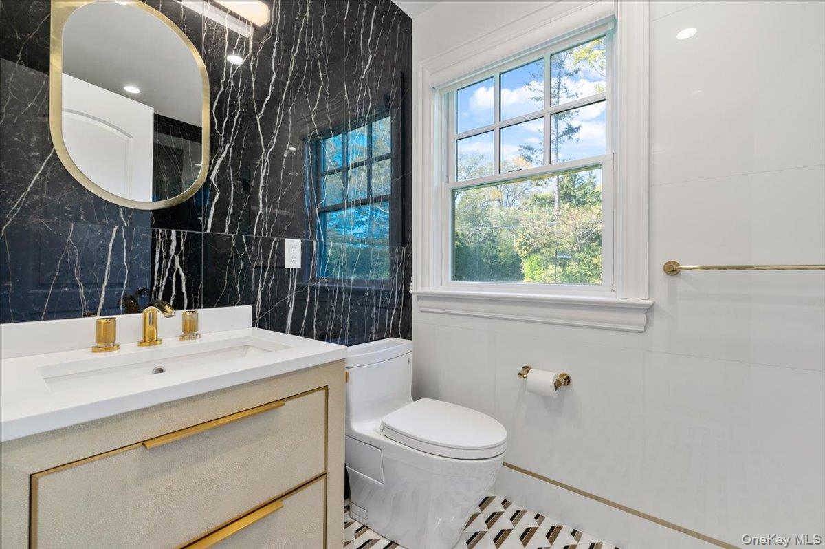 205 Hewlett Neck Road Woodmere, NY 11598 - Photo 21 of 50 a bathroom with a toilet a sink and mirror