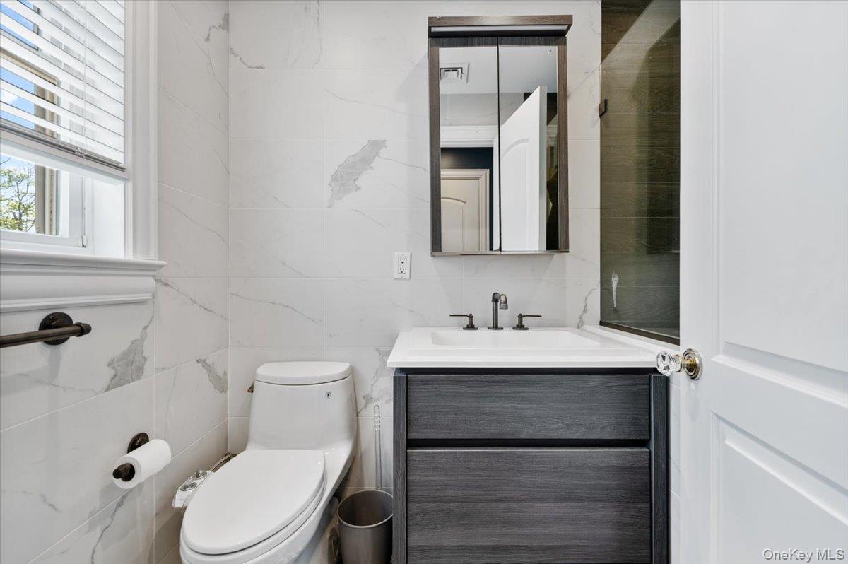 205 Hewlett Neck Road Woodmere, NY 11598 - Photo 28 of 50 a bathroom with a toilet sink and mirror