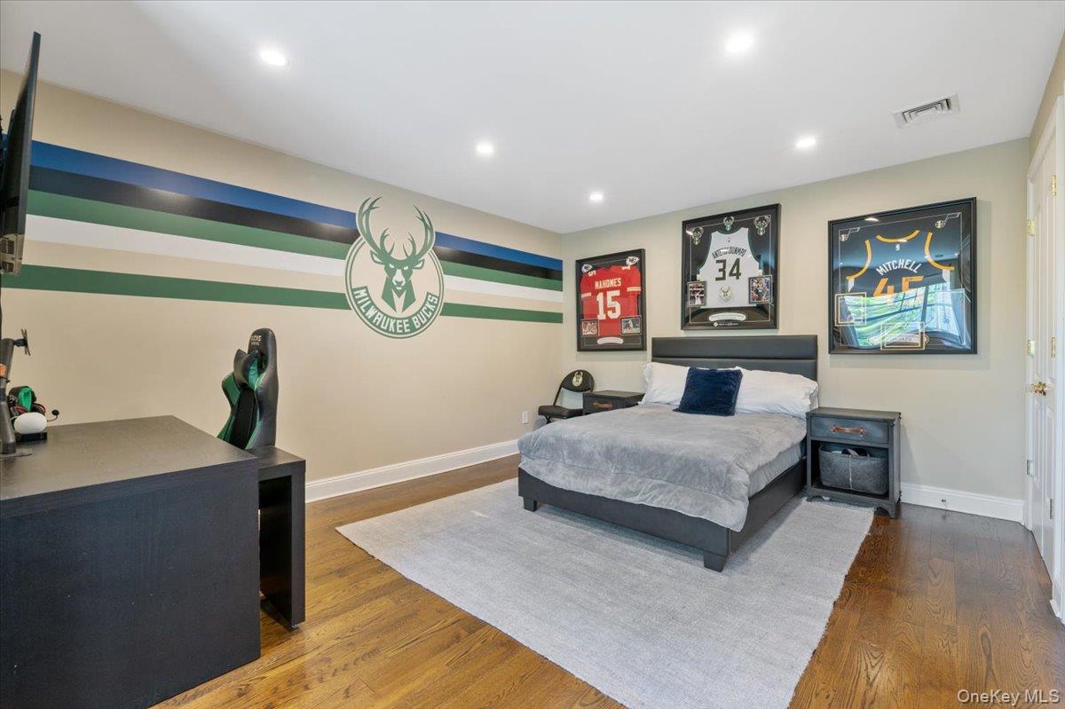 205 Hewlett Neck Road Woodmere, NY 11598 - Photo 29 of 50 a spacious bedroom with a bed and a table
