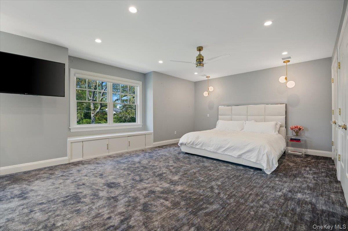 205 Hewlett Neck Road Woodmere, NY 11598 - Photo 31 of 50 a spacious bedroom with a large bed and a flat screen tv
