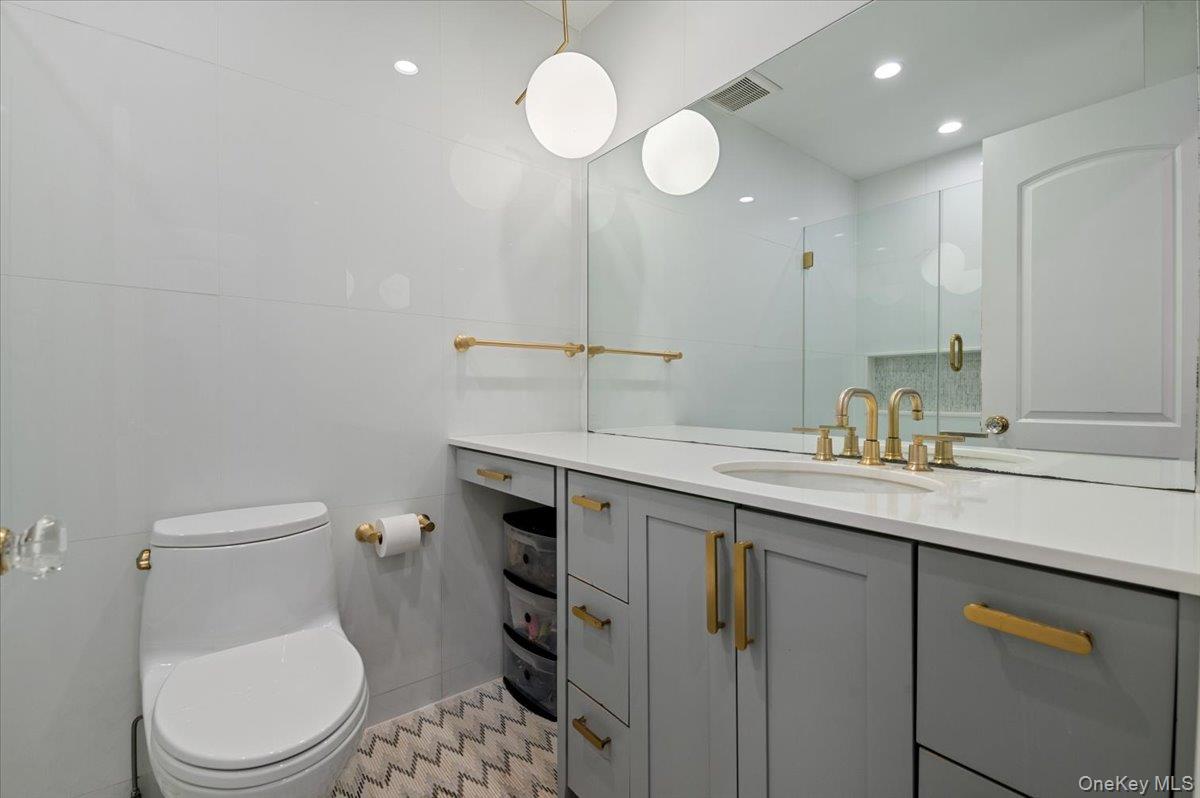 205 Hewlett Neck Road Woodmere, NY 11598 - Photo 32 of 50 a bathroom with a toilet a sink and mirror