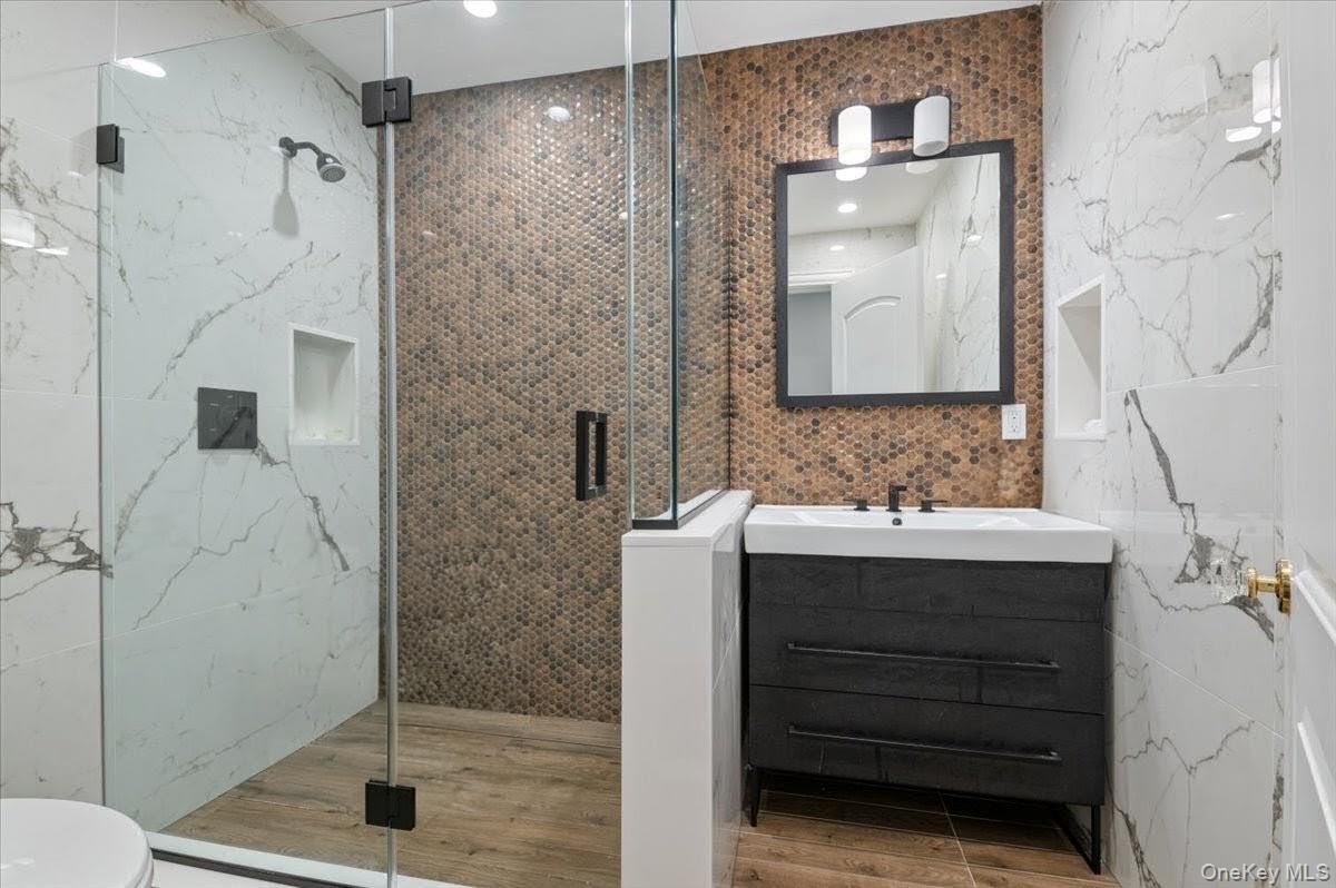 205 Hewlett Neck Road Woodmere, NY 11598 - Photo 34 of 50 a bathroom with a shower sink and mirror