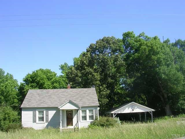 1719 Virgilina Road Roxboro, NC 27573 - Photo 3 of 3 a backyard of a house with plants and large trees