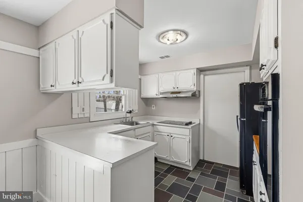 a kitchen with stainless steel appliances a sink a stove a refrigerator and cabinets