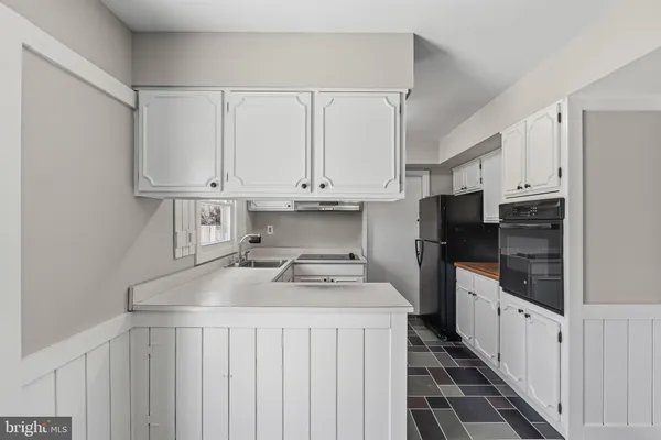 a kitchen with granite countertop a sink a stove and refrigerator