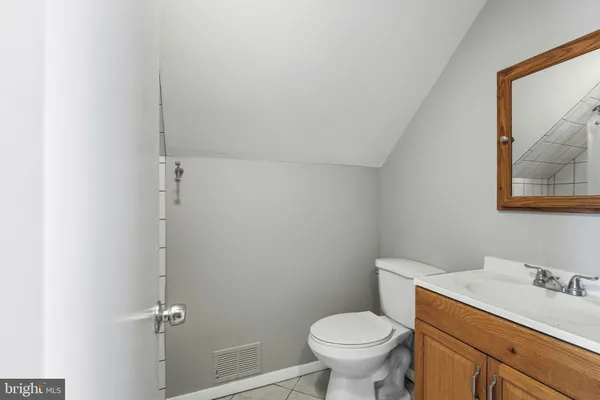 a bathroom with a granite countertop toilet and a sink
