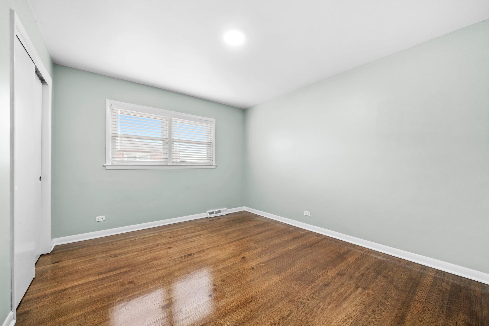 10537 Austin Avenue, Unit 2 Chicago Ridge, IL 60415 - Photo 13 of 19 an empty room with wooden floor and windows