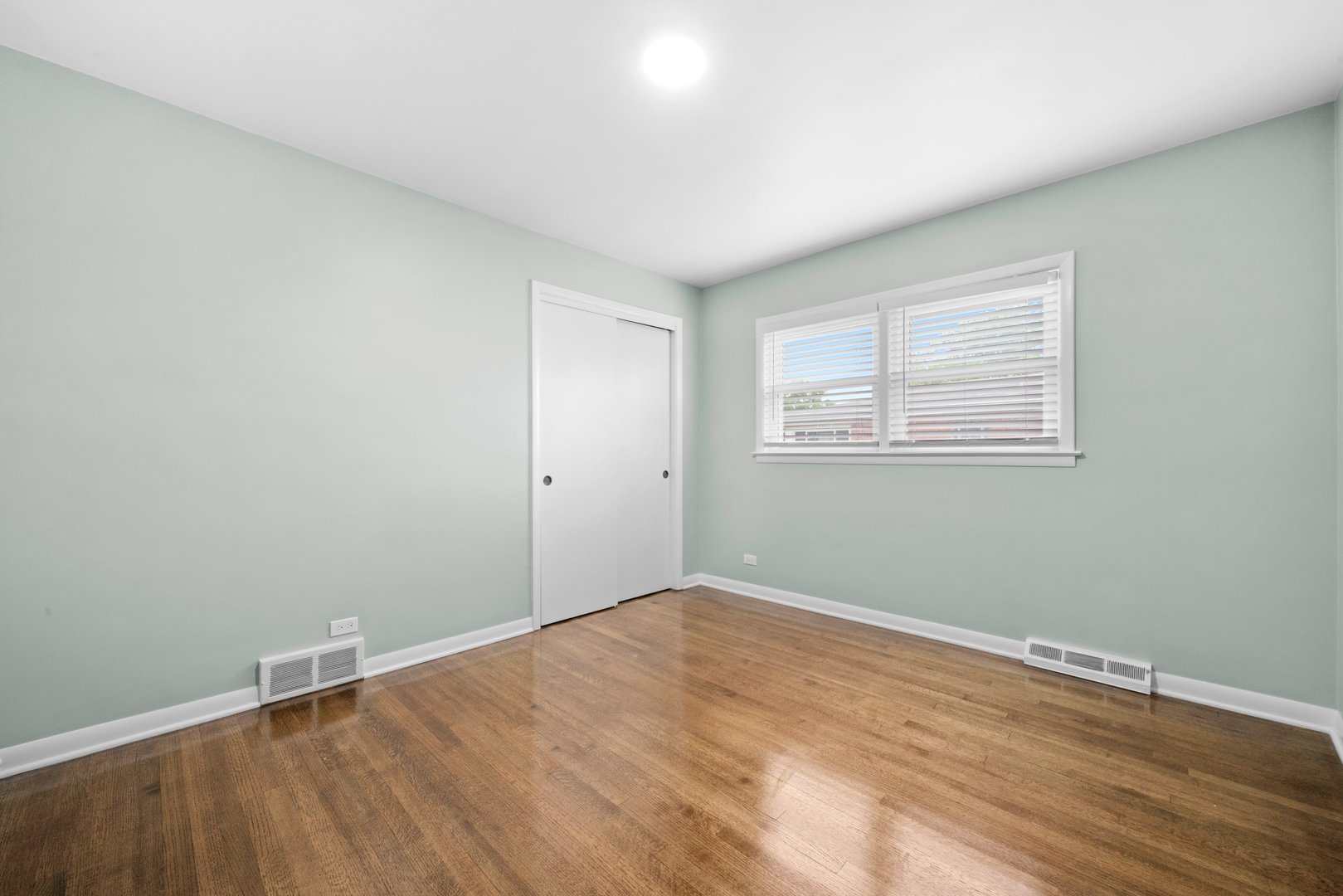10537 Austin Avenue, Unit 2 Chicago Ridge, IL 60415 - Photo 14 of 19 an empty room with wooden floor and windows