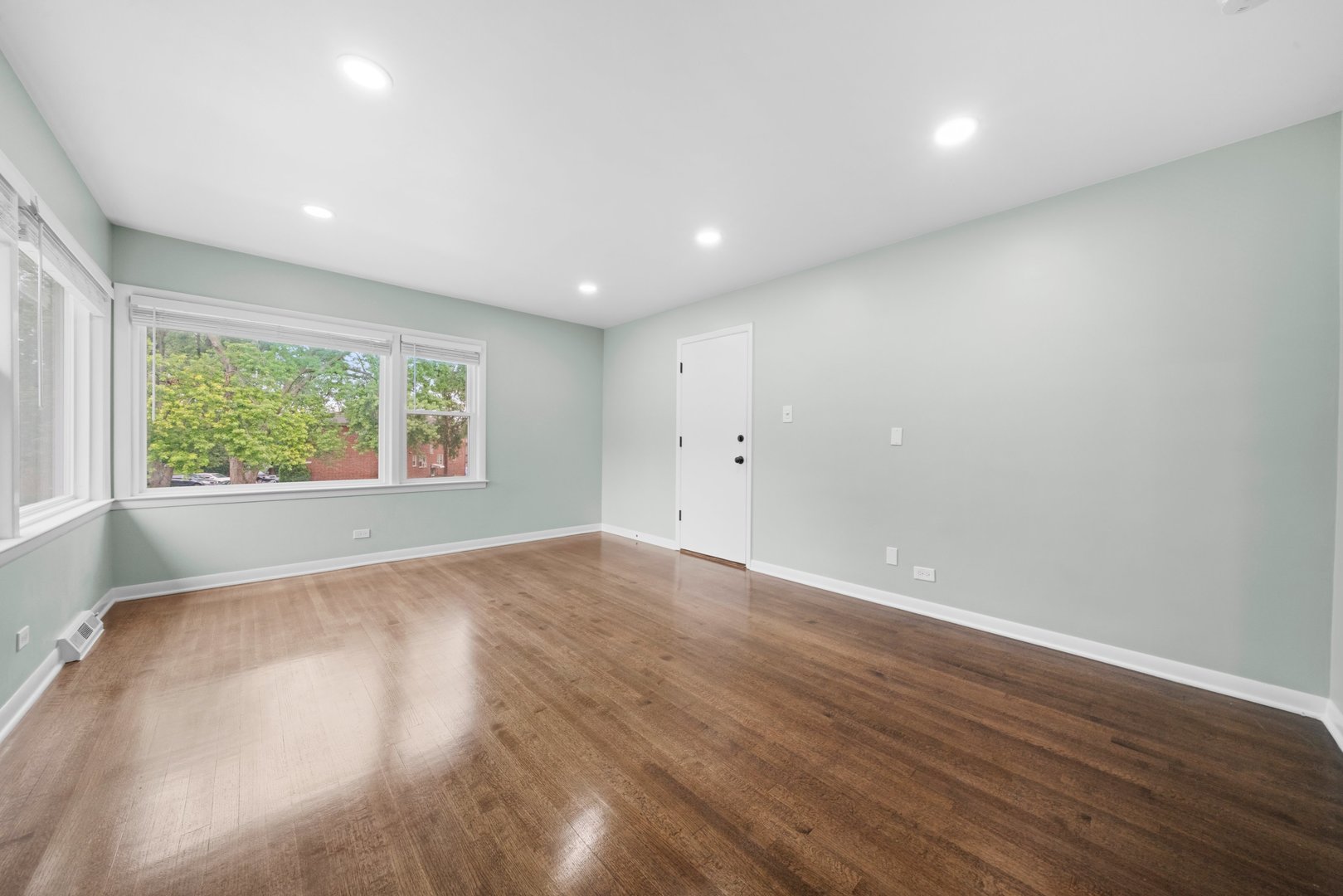 10537 Austin Avenue, Unit 2 Chicago Ridge, IL 60415 - Photo 4 of 19 an empty room with wooden floor and windows