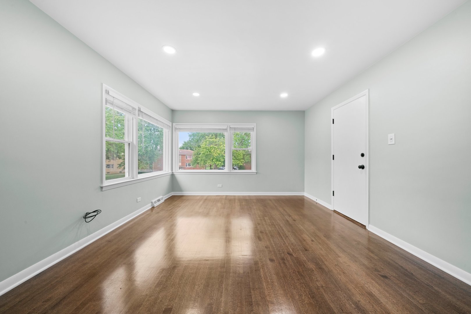10537 Austin Avenue, Unit 2 Chicago Ridge, IL 60415 - Photo 5 of 19 an empty room with wooden floor and windows