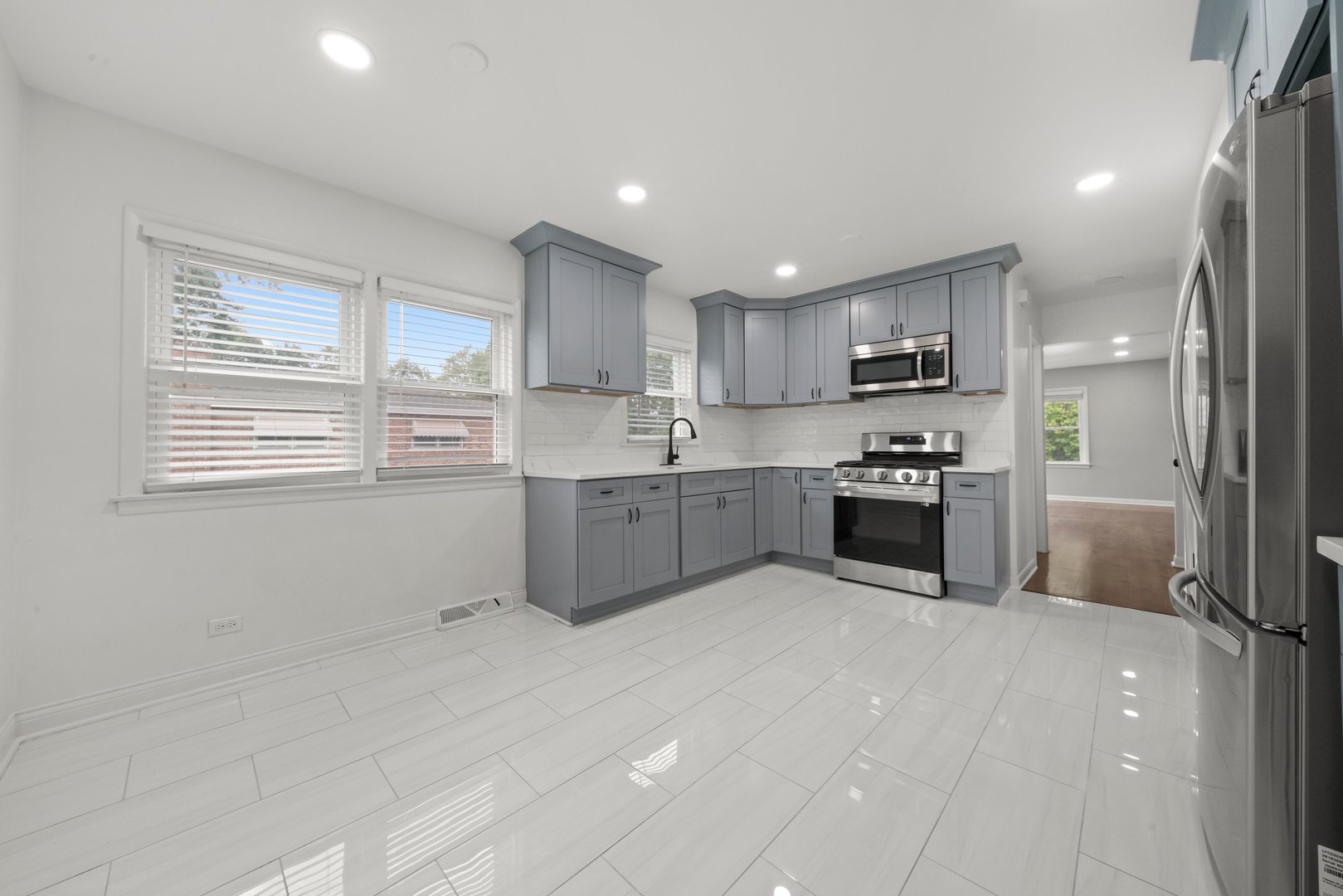 10537 Austin Avenue, Unit 2 Chicago Ridge, IL 60415 - Photo 7 of 19 a large kitchen with stainless steel appliances granite countertop a sink counter space cabinets and a large window