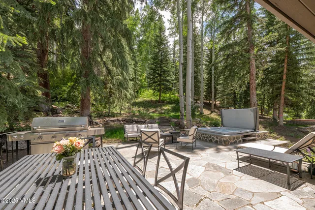 a view of a patio with a dining table and chairs with wooden floor and fence