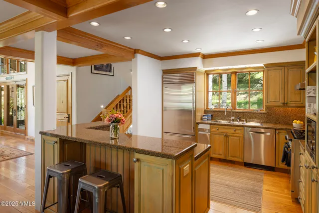 a kitchen with stainless steel appliances kitchen island granite countertop a stove and a refrigerator