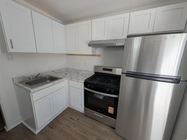 a kitchen with white cabinets and a stove top oven