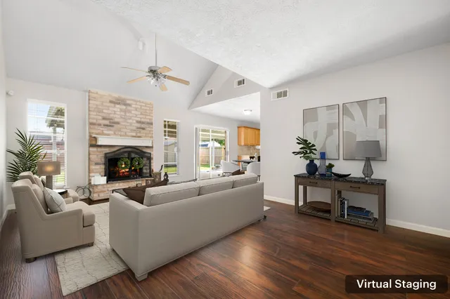 a living room with furniture a large window and a fireplace