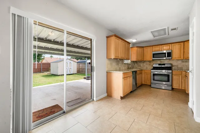a kitchen with stainless steel appliances granite countertop a stove a sink and a refrigerator