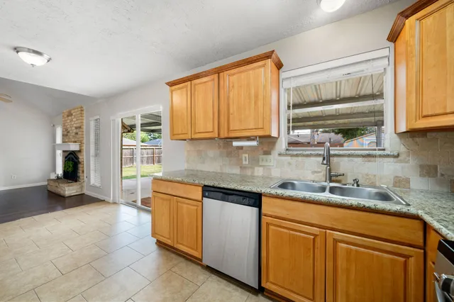 a kitchen with stainless steel appliances granite countertop a sink stove and cabinets