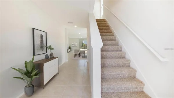 a view of staircase with white walls and frames on wall