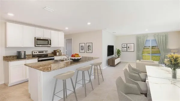 a kitchen with stainless steel appliances granite countertop a stove a sink a refrigerator a microwave a dining table and chairs