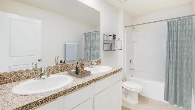 a bathroom with a granite countertop sink a toilet and shower