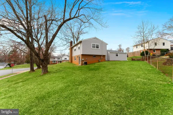 a front view of house with yard and trees in the background