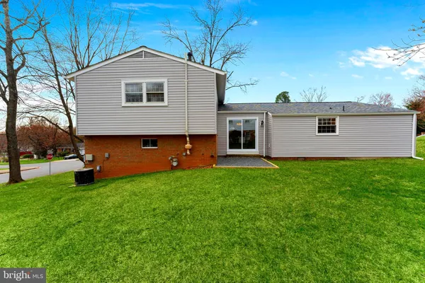 a front view of a house with a yard and trees