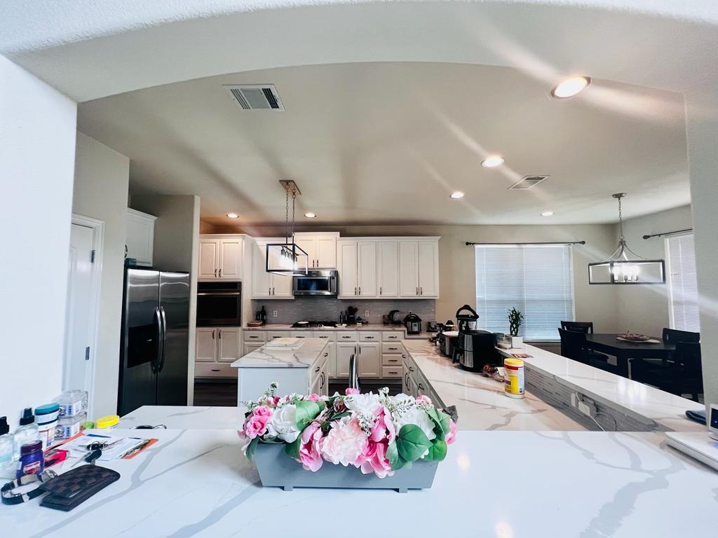 3604 Rams Horn Way Round Rock, TX 78665 - Photo 16 of 26 A well-lit kitchen boasts elegant quartz countertops, an inviting island, and modern stainless steel appliances.