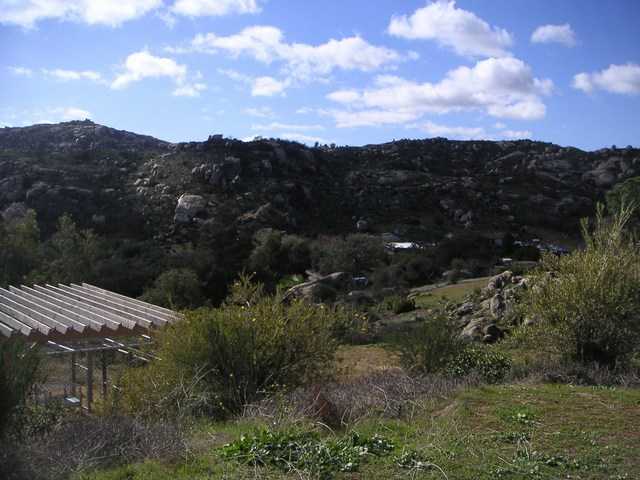 20591 Bee Valley Road Jamul, CA 91935 - Photo 2 of 9 A view of the back yard. There is 3.9 acres & the house sits just about in the middle of it. You can see the dog kennel /predator proof enclosure to the right of this photo. It is 15x30 with a pergola shade top, fully enclosed w/ electricity & water