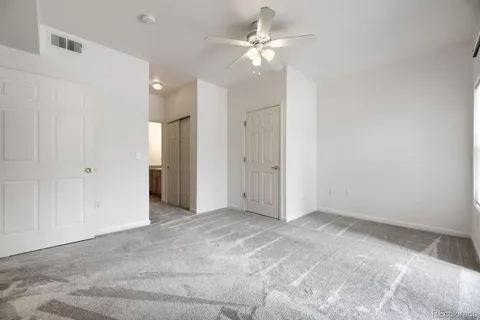 en empty room with fan and a ceiling fan