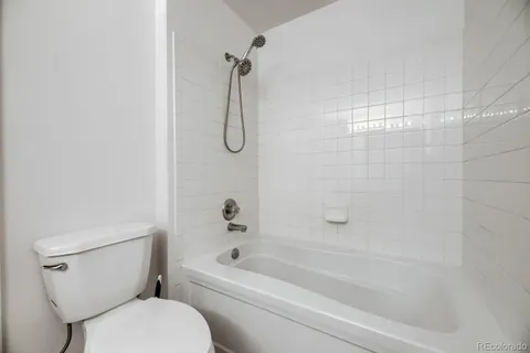 a bathroom with a toilet and a bath tub
