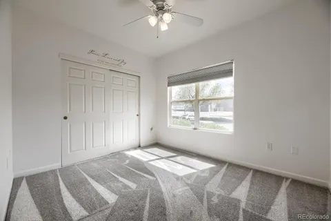 a view of a livingroom with a ceiling fan and window