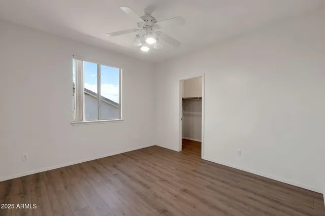 a view of a room with wooden floor and a ceiling fan
