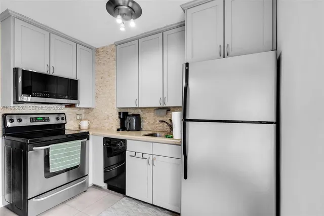 a kitchen with stainless steel appliances a stove a sink and a microwave