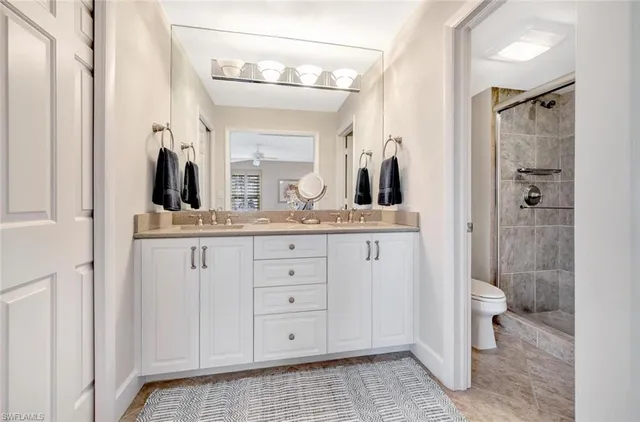 a bathroom with a double vanity sink toilet and shower