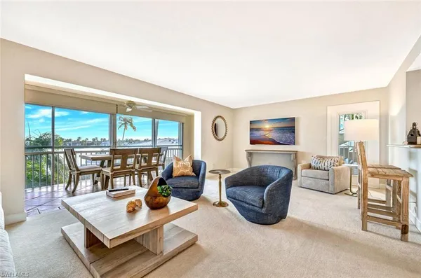 a living room with furniture a flat screen tv and a floor to ceiling window