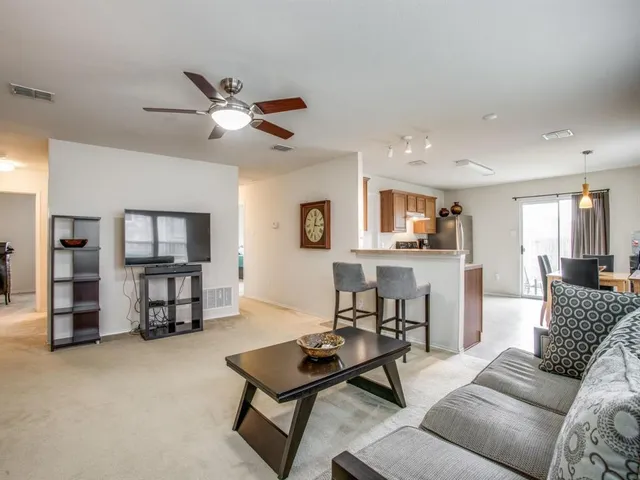 a living room with furniture and a dining table with wooden floor