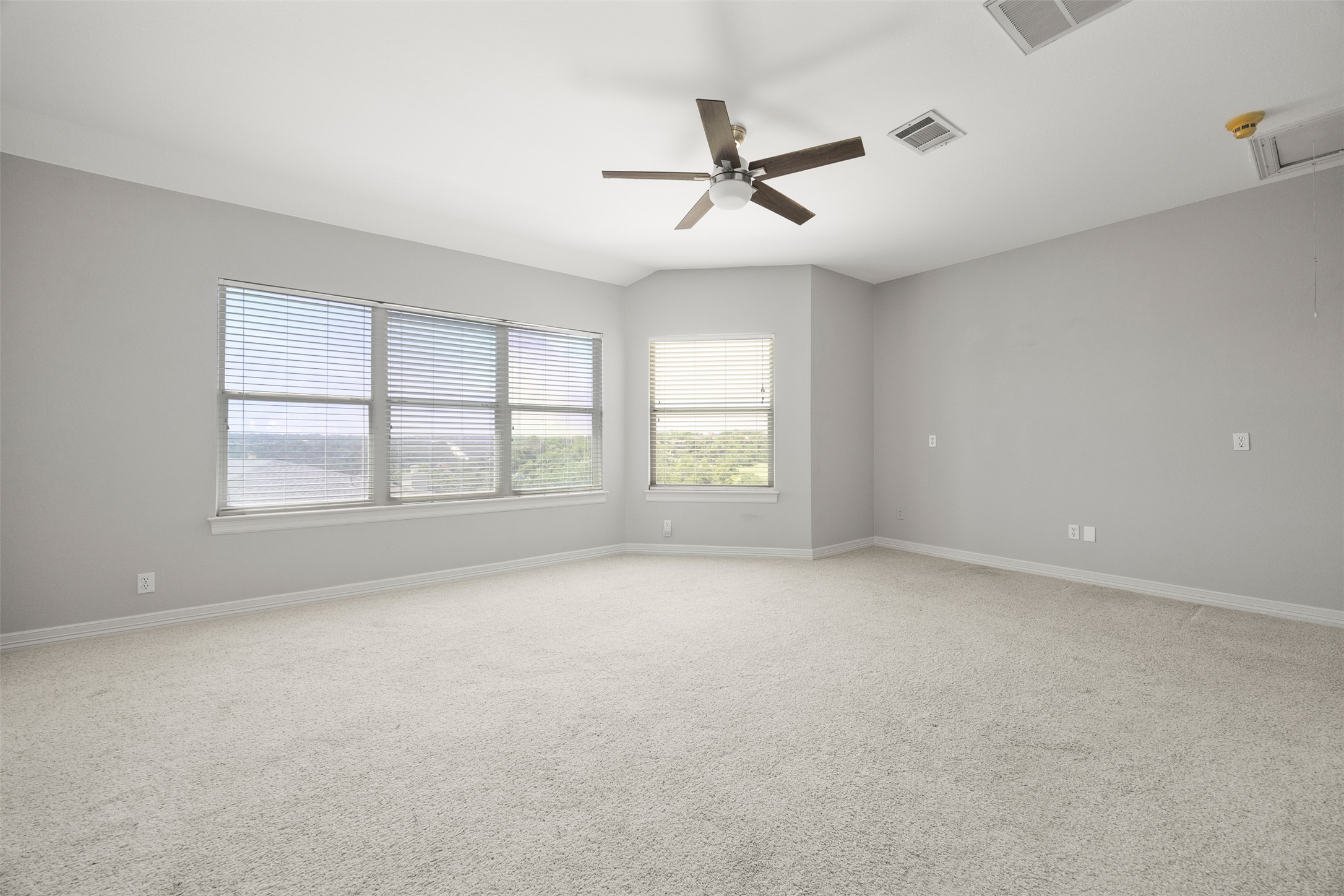 9300 Simmons Road Austin, TX 78759 - Photo 9 of 17 A spacious room offers ample natural light and comfortable carpeting, perfect for relaxation.