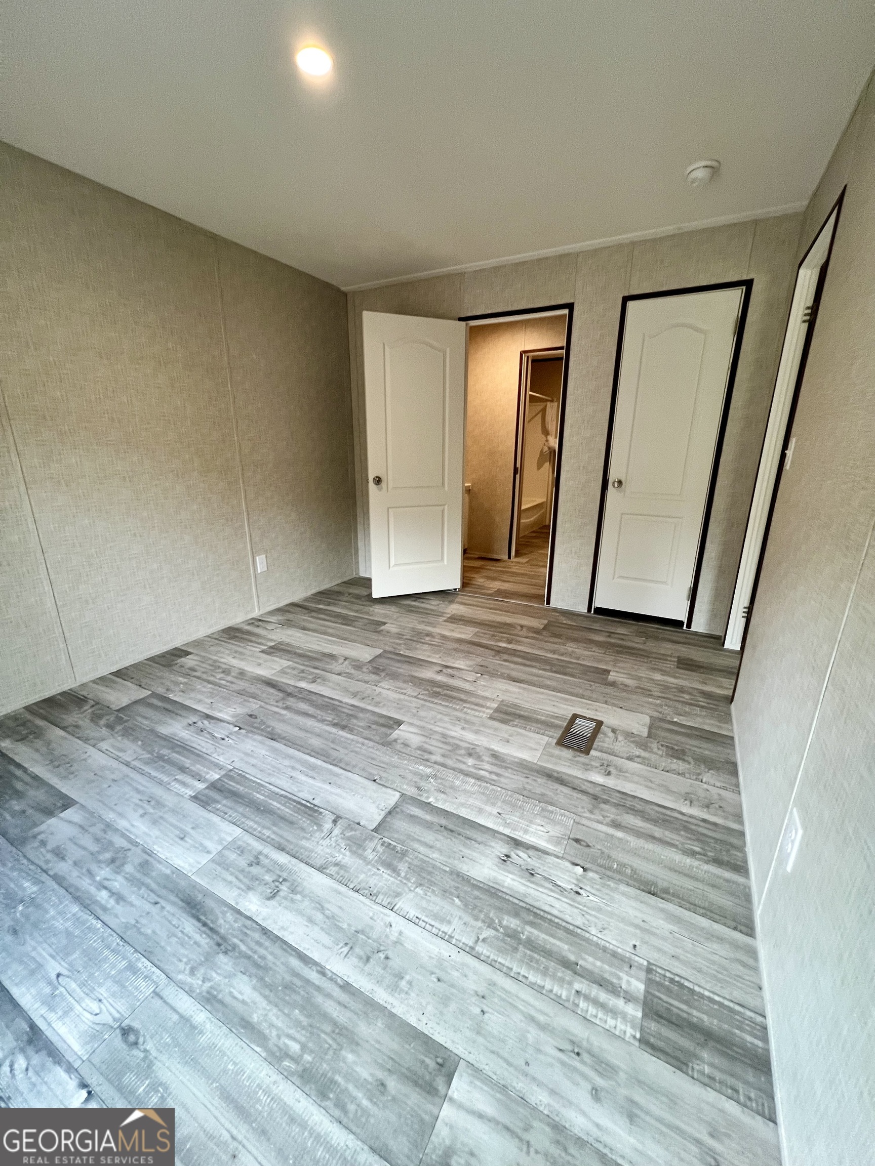 223 Pelican Road Woodbine, GA 31569 - Photo 14 of 18 a view of an empty room with wooden floor and a mirror