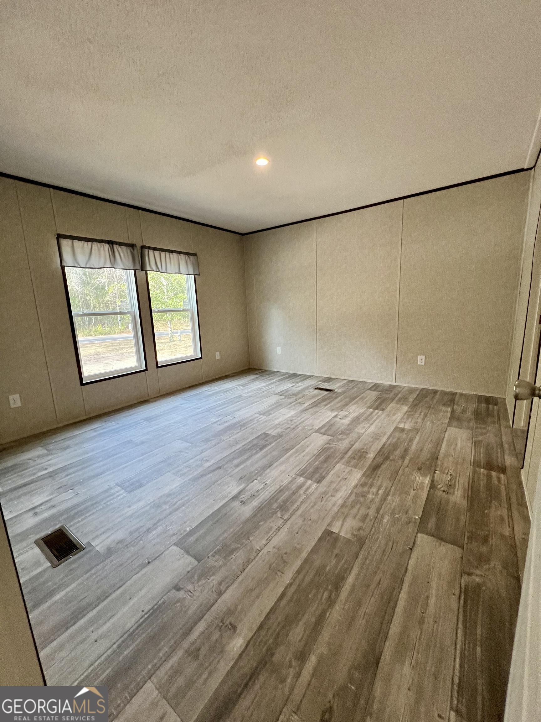 223 Pelican Road Woodbine, GA 31569 - Photo 4 of 18 an empty room with wooden floor and windows