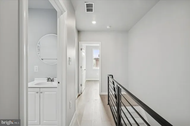a view of a hallway with wooden floor and staircase