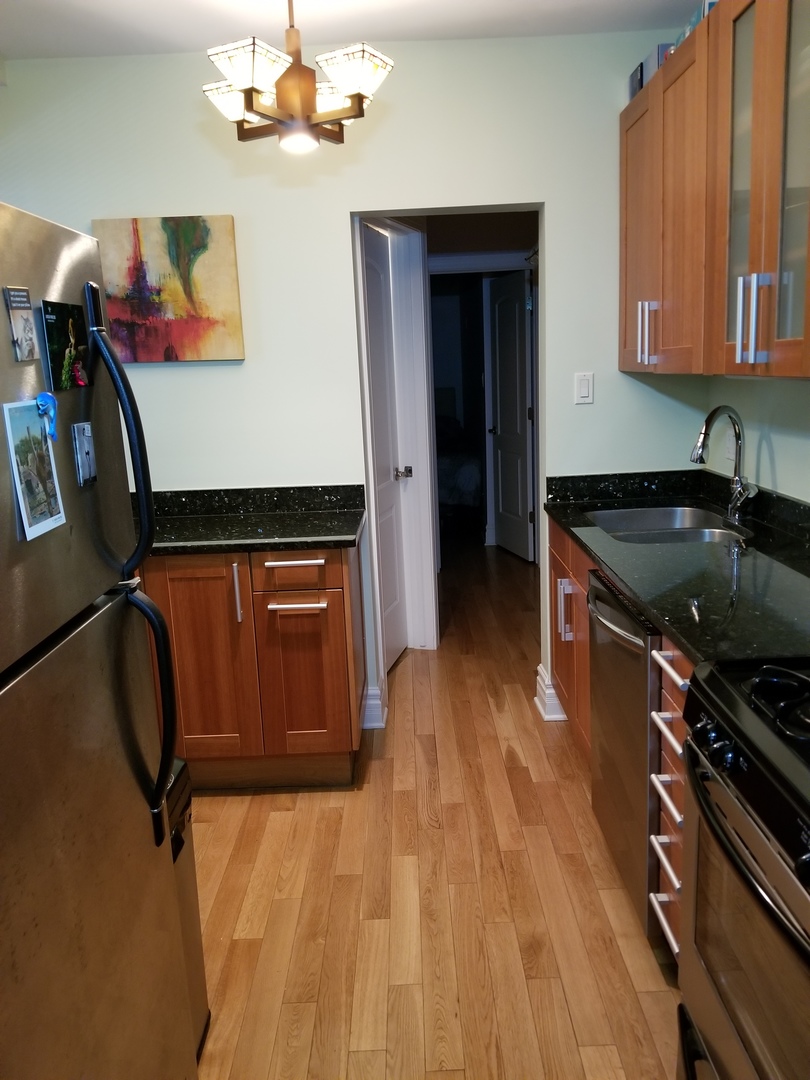433 West Briar Place, Unit 1D Chicago, IL 60657 - Photo 4 of 12 a kitchen with wooden floors and a sink