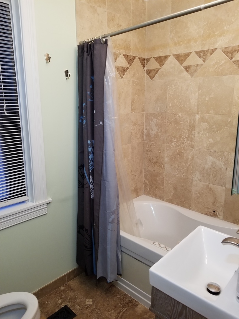 433 West Briar Place, Unit 1D Chicago, IL 60657 - Photo 7 of 12 a bathroom with a sink and a tub