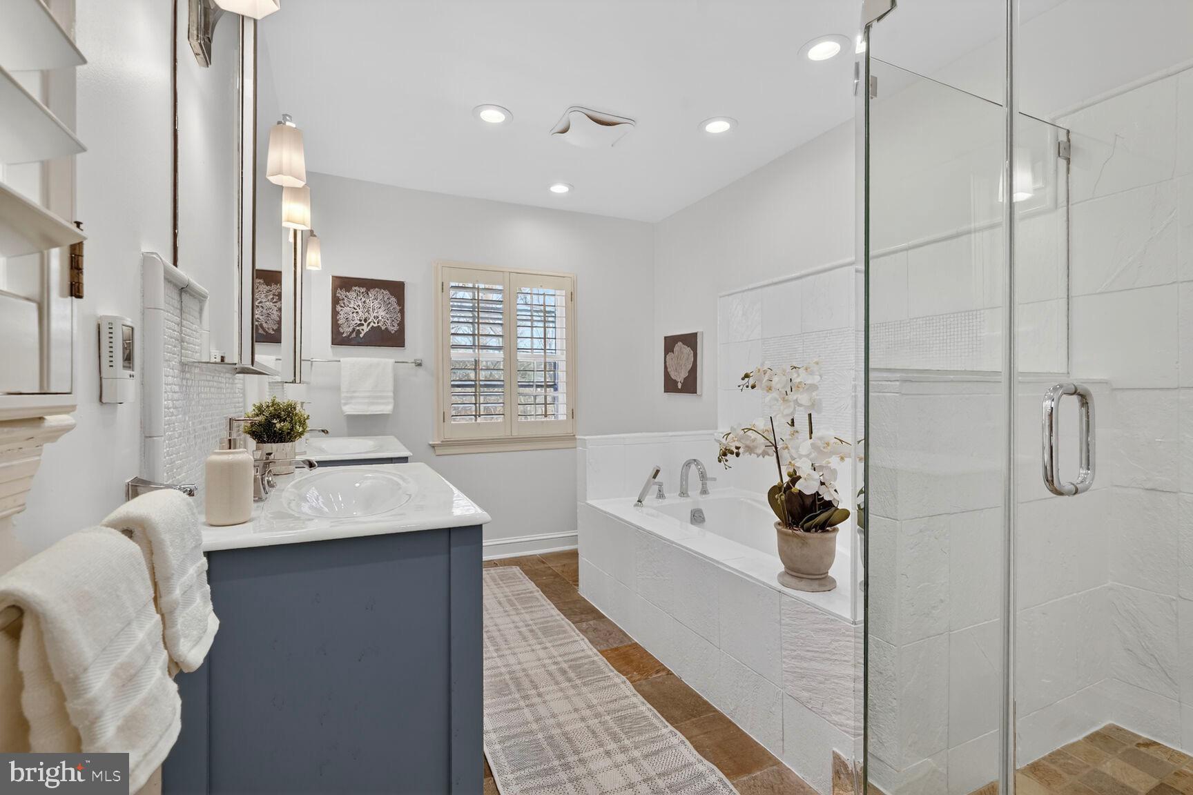 3262 Aberfoyle Place Northwest Washington, DC 20015 - Photo 29 of 64 a large white bathroom with a tub sink and mirror