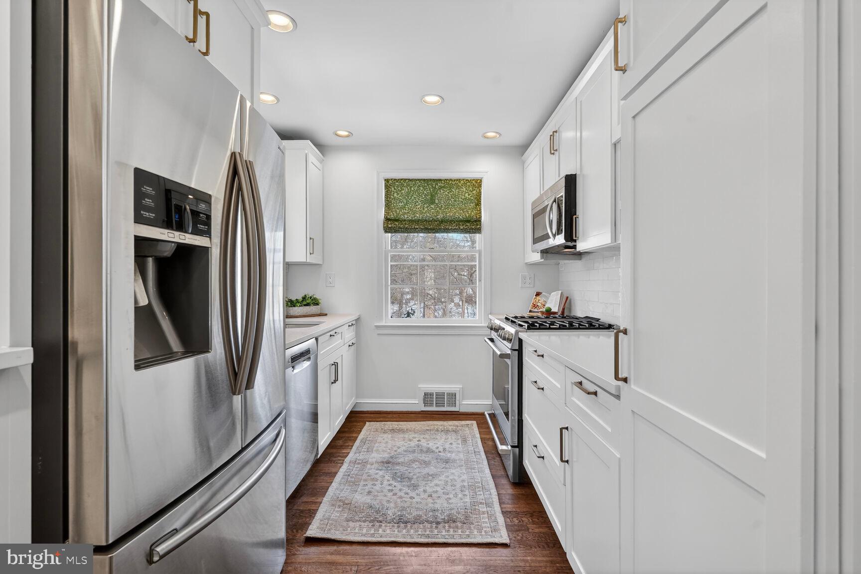 3262 Aberfoyle Place Northwest Washington, DC 20015 - Photo 10 of 64 a kitchen with white cabinets and stainless steel appliances