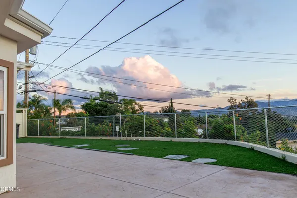 a view of a house with a big yard and a large tree
