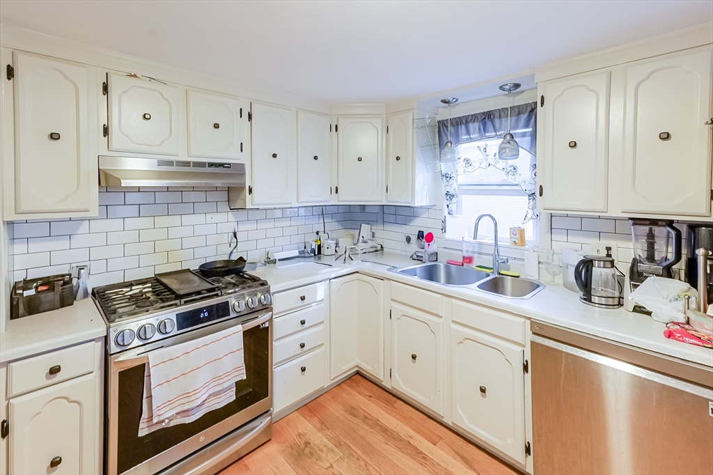 5 Oliver Street Randolph, MA 02368 - Photo 14 of 29 a kitchen with granite countertop a sink stove and cabinets